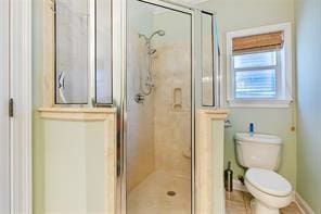 bathroom featuring an enclosed shower and toilet