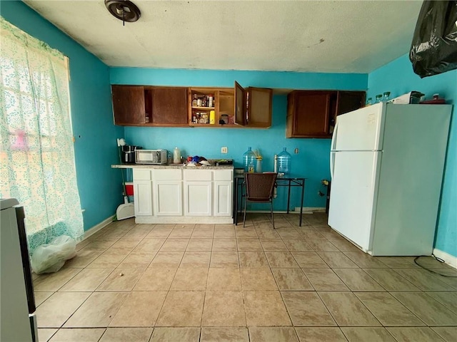 kitchen featuring white refrigerator and light tile patterned floors