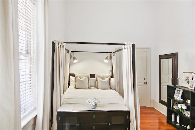 bedroom with multiple windows and hardwood / wood-style flooring