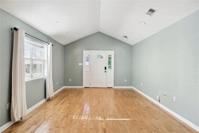 foyer entrance with light hardwood / wood-style floors and vaulted ceiling