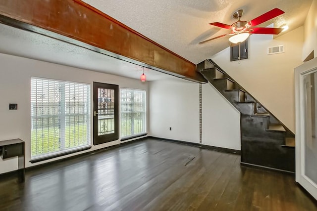 interior space featuring ceiling fan, a textured ceiling, dark hardwood / wood-style floors, and plenty of natural light