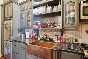 bar featuring gray cabinets, sink, and tasteful backsplash