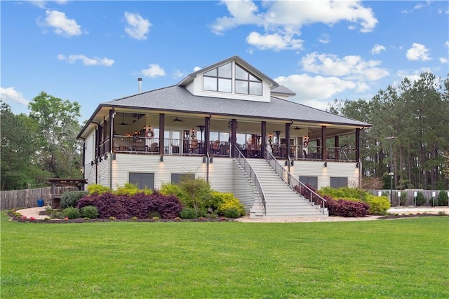 rear view of house with ceiling fan and a lawn