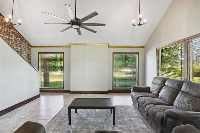 living room with ceiling fan with notable chandelier, high vaulted ceiling, tile floors, and brick wall