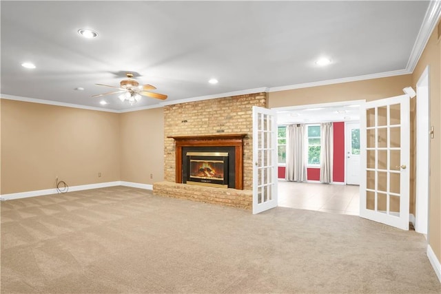 unfurnished living room with ornamental molding, light colored carpet, a brick fireplace, and ceiling fan