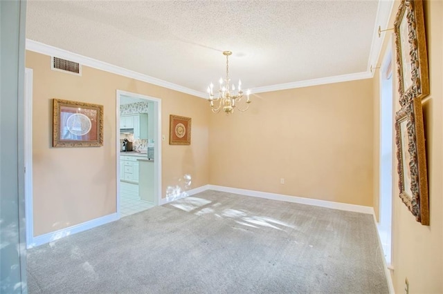 unfurnished room with a textured ceiling, a notable chandelier, carpet, and crown molding