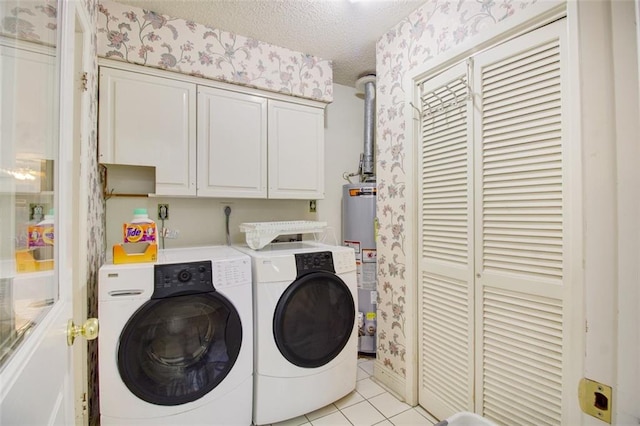 clothes washing area with hookup for an electric dryer, washing machine and dryer, gas water heater, light tile flooring, and a textured ceiling