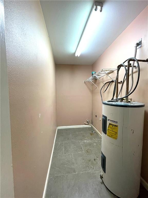 laundry room featuring water heater and tile flooring