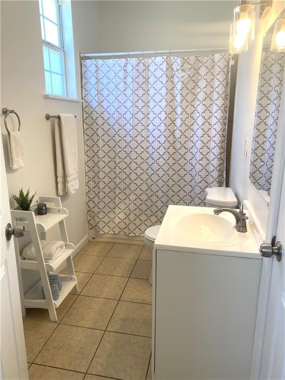 bathroom featuring toilet, tile flooring, and large vanity