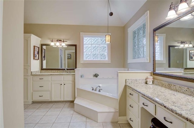 bathroom with tile patterned flooring, a bathing tub, and vanity