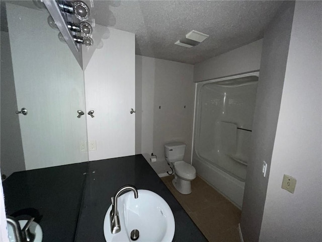 bathroom with a textured ceiling, toilet, and sink