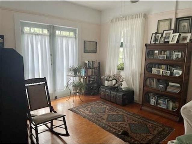 living area with a wealth of natural light and wood-type flooring