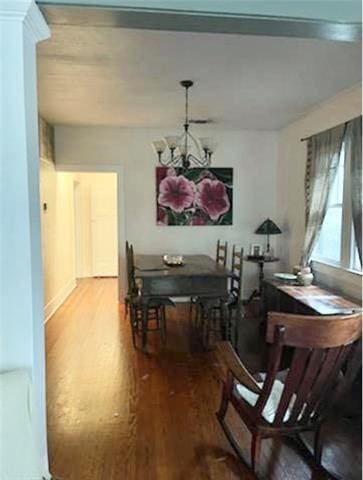 dining room with hardwood / wood-style flooring and an inviting chandelier