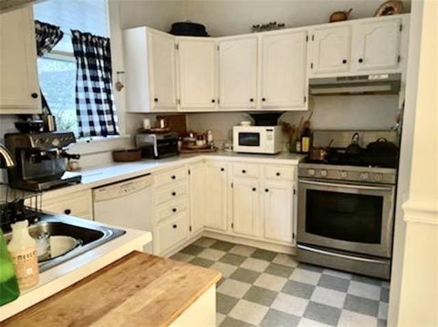 kitchen with white cabinets, sink, white appliances, and light tile flooring