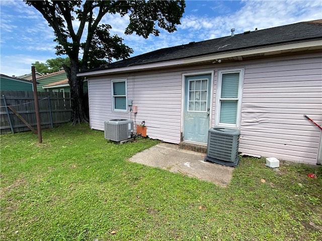 back of house with a lawn and central air condition unit