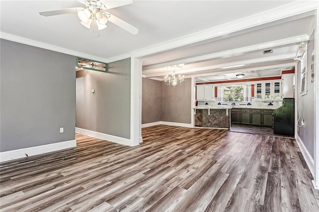 unfurnished living room featuring ceiling fan with notable chandelier, hardwood / wood-style flooring, and ornamental molding