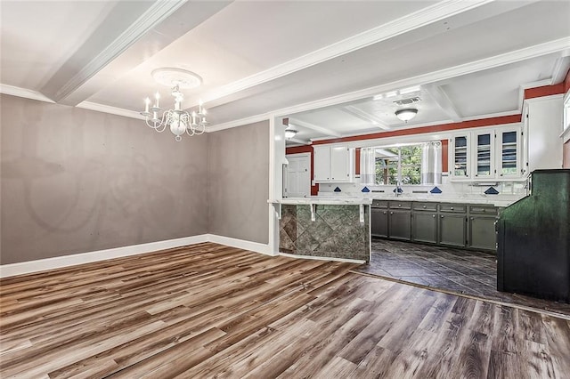 kitchen featuring beamed ceiling, dark tile floors, white cabinetry, decorative light fixtures, and an inviting chandelier