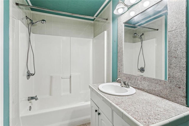 bathroom with vanity with extensive cabinet space and tiled shower / bath