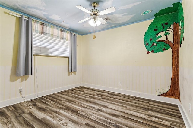 spare room with dark hardwood / wood-style flooring and ceiling fan