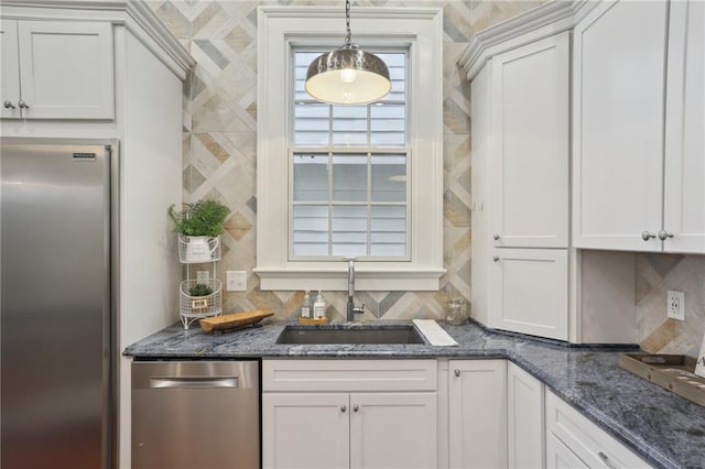 kitchen with appliances with stainless steel finishes, sink, tasteful backsplash, and white cabinets