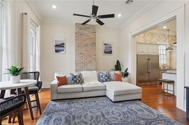 living room with ornamental molding, dark wood-type flooring, ceiling fan, and sink