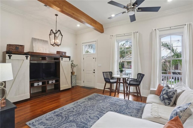 living room with beam ceiling, ceiling fan with notable chandelier, crown molding, and dark wood-type flooring