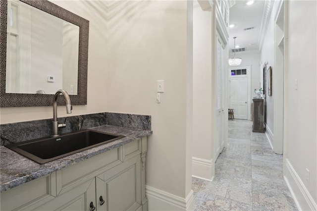 bathroom featuring ornamental molding, tile floors, and sink