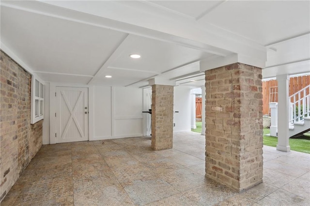 basement featuring brick wall and tile flooring