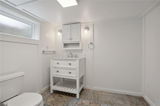 bathroom featuring toilet, tile flooring, and vanity