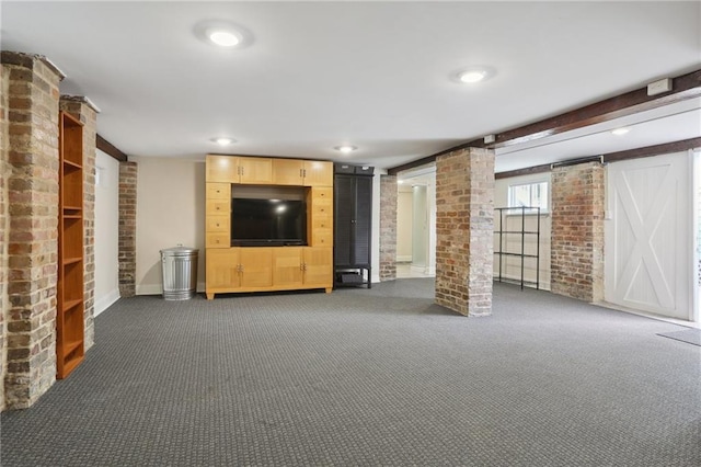 unfurnished living room featuring dark colored carpet and brick wall