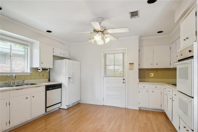 kitchen with light wood-type flooring, white appliances, backsplash, and white cabinetry