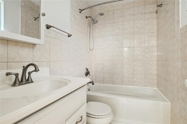 full bathroom featuring tile walls, tiled shower / bath combo, vanity, and toilet