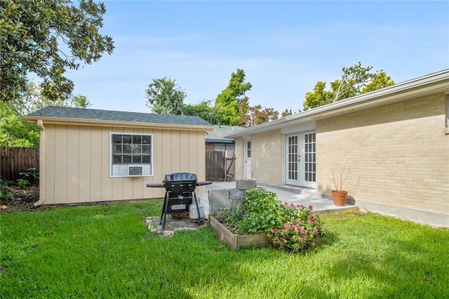 back of house featuring french doors, a lawn, and a patio area