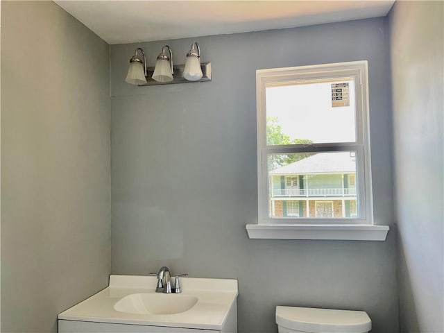 bathroom featuring vanity, a healthy amount of sunlight, and toilet