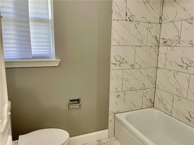 bathroom featuring washtub / shower combination and toilet