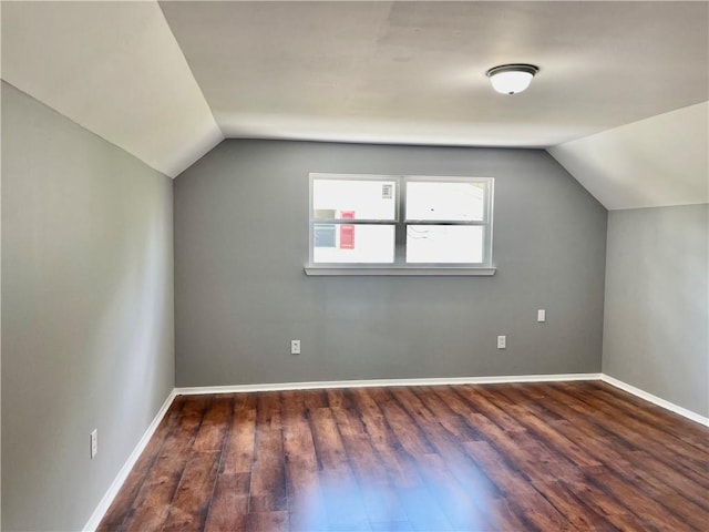 bonus room with dark hardwood / wood-style floors and vaulted ceiling