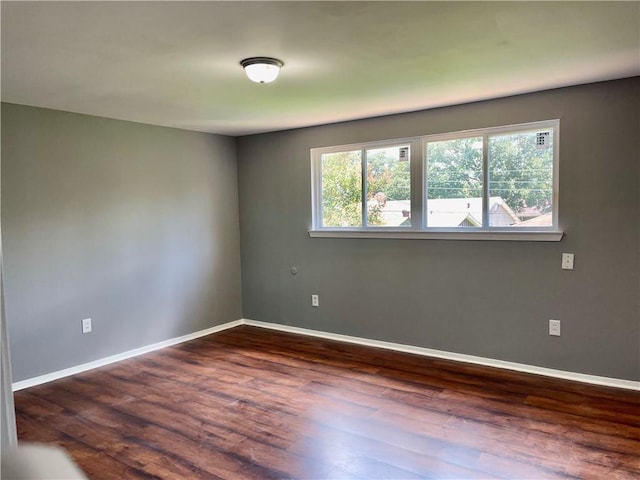 unfurnished room with dark wood-type flooring