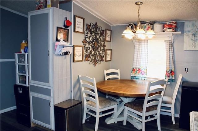 dining space featuring a notable chandelier, a textured ceiling, and wood finished floors