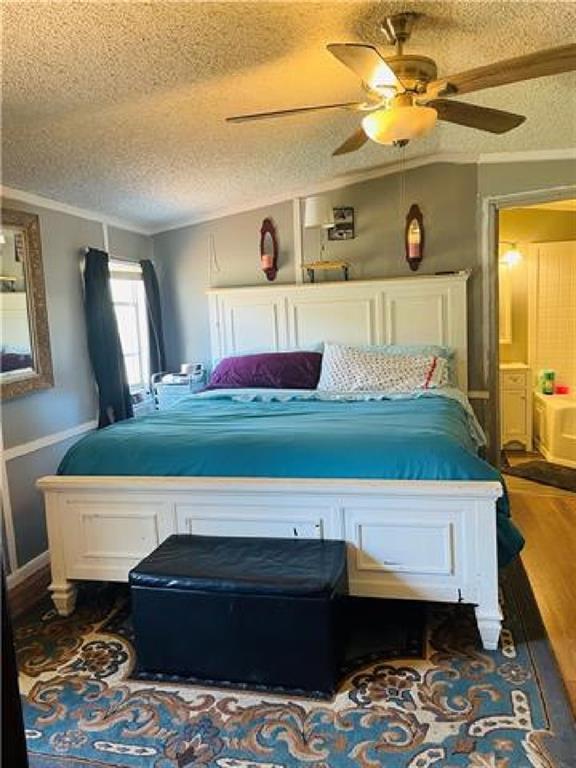 bedroom with dark hardwood / wood-style flooring, ceiling fan, and a textured ceiling