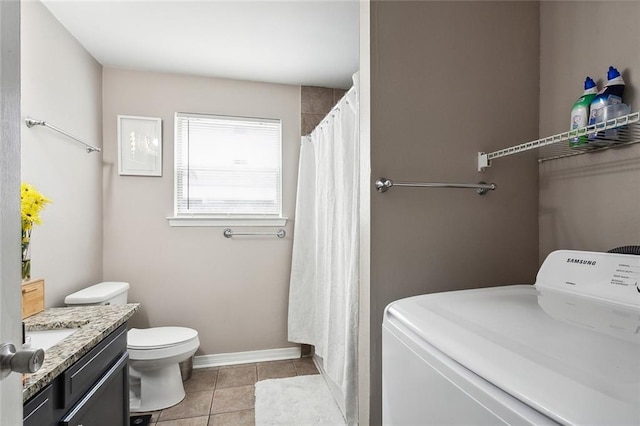 interior space with tile floors, vanity, toilet, and washer / dryer