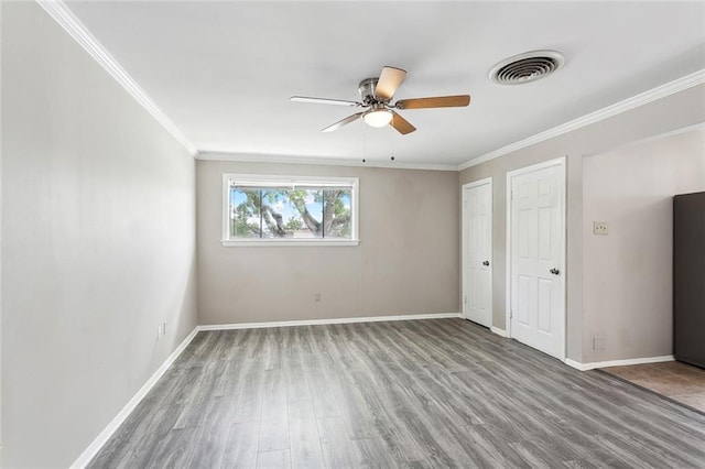 spare room featuring wood-type flooring, ceiling fan, and ornamental molding