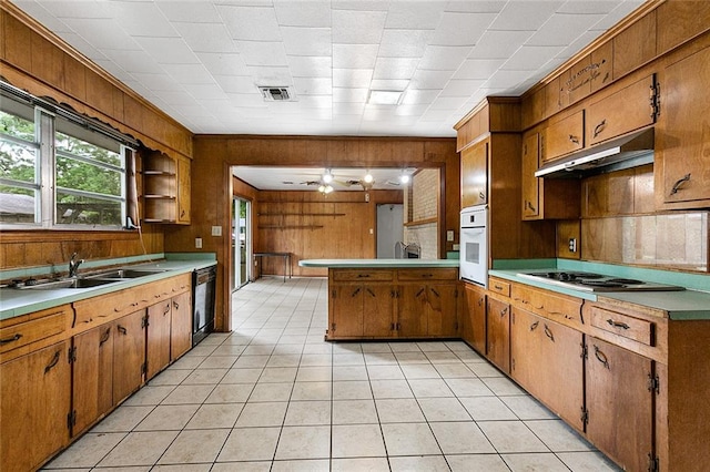 kitchen with white oven, dishwasher, light tile floors, and gas cooktop