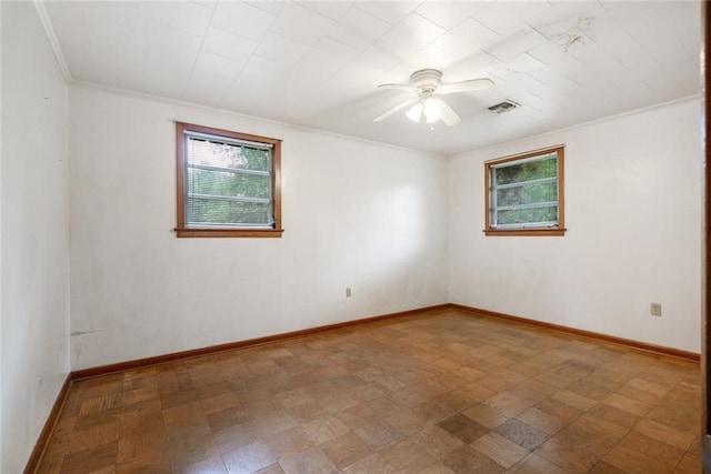 empty room featuring crown molding, tile floors, and ceiling fan