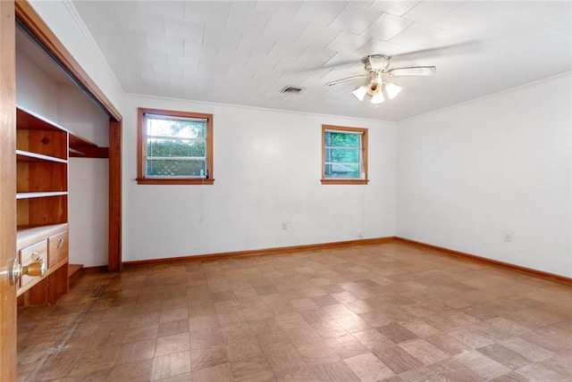 spare room featuring ceiling fan, tile floors, and ornamental molding