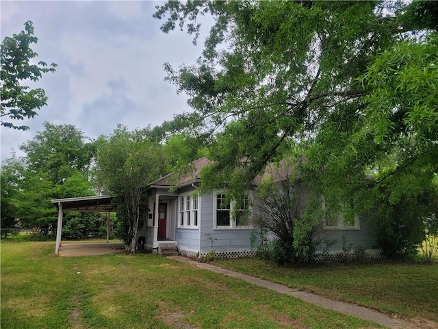 view of front of home with a carport and a front lawn