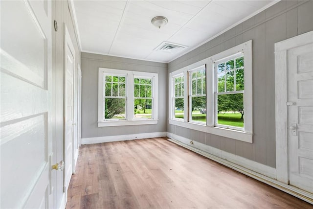 unfurnished sunroom featuring a baseboard heating unit