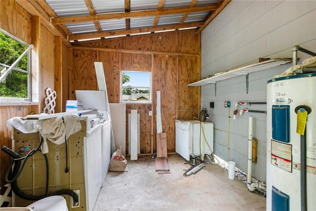 interior space featuring a healthy amount of sunlight, concrete floors, vaulted ceiling, and electric water heater