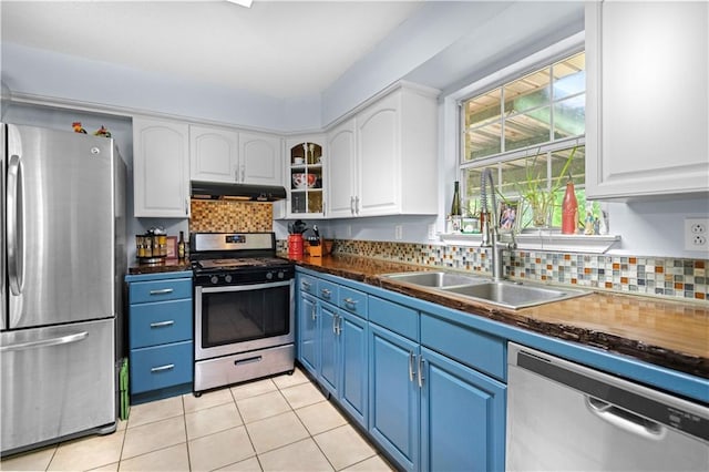 kitchen with blue cabinets, white cabinets, and appliances with stainless steel finishes