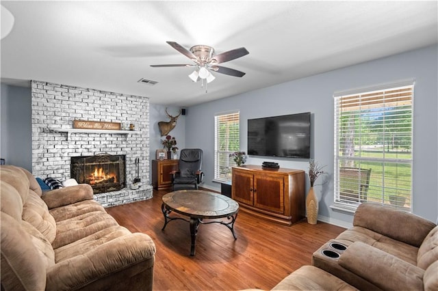 living room with a fireplace, wood-type flooring, and ceiling fan