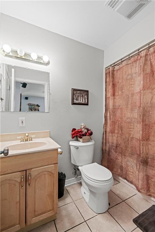 bathroom featuring vanity, toilet, and tile patterned flooring